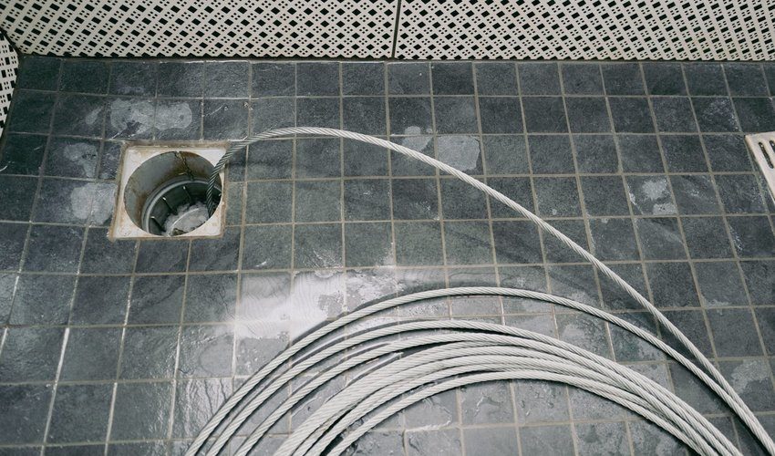 Drain cleaning cable clearing a blocked drain