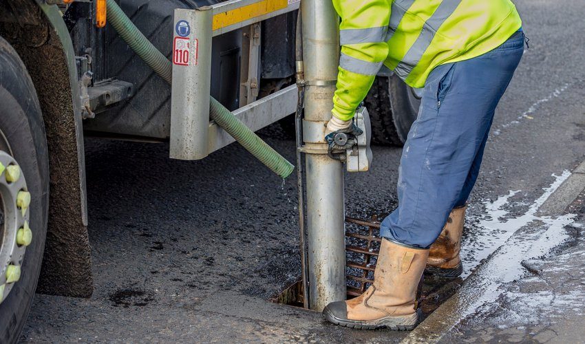 Engineer jetting a blocked road gully
