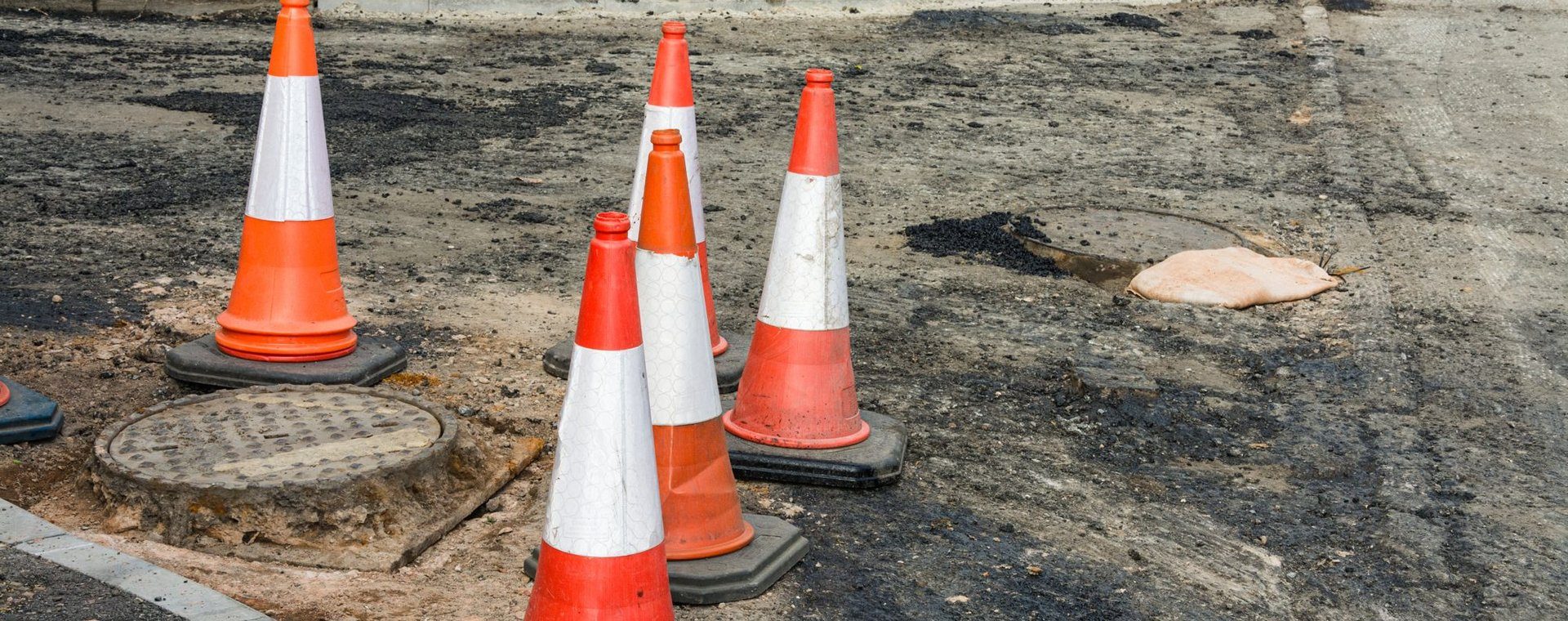 Safety cones around a manhole on a UK street