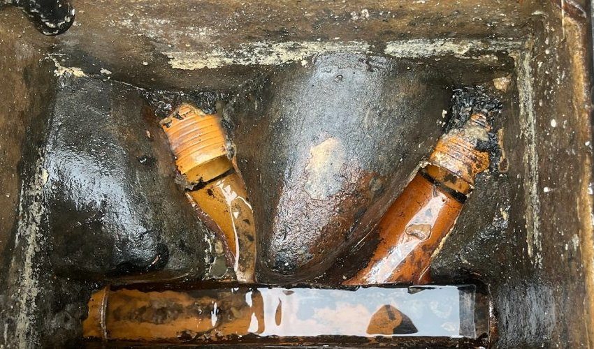 Open inspection chamber showing clay drainage pipes