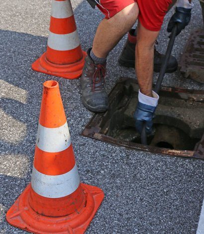 Engineer setting up a drain camera at a manhole